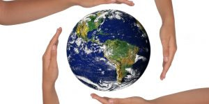 Young Hands Surrounding the Globe of the Future